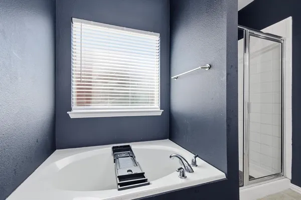 a white bath tub sitting in a bathroom next to a window