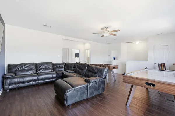 a living room with furniture and a wooden floor