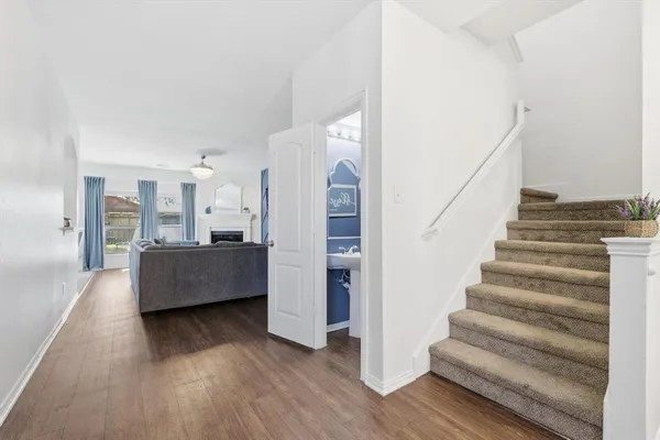 a living room with furniture and entryway with wooden floor
