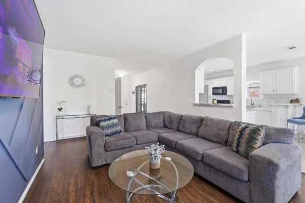 a living room with furniture and a wooden floor