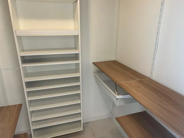 a view of walk in closet with empty racks