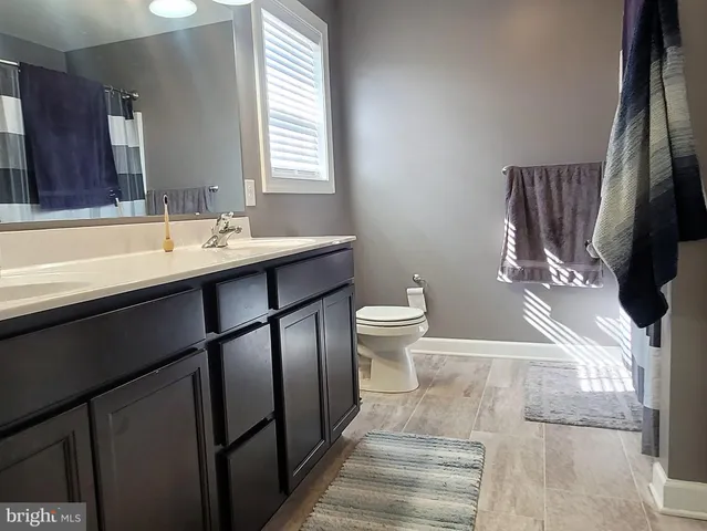 a bathroom with a sink toilet and a mirror