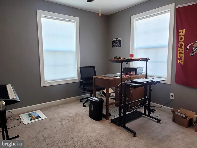 a view of a workspace with furniture and a window