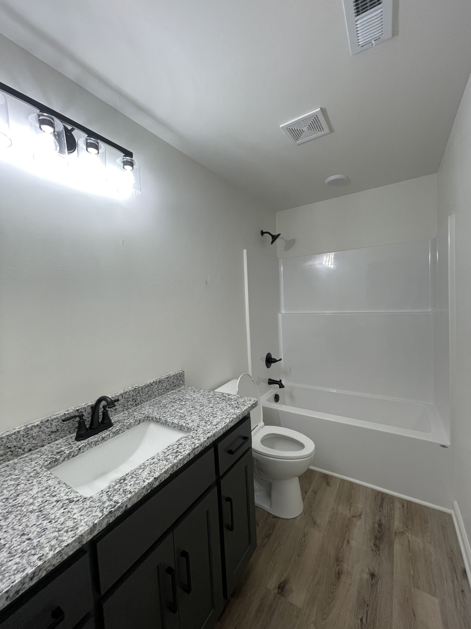 2907 Union Camp Road Lafayette, TN 37083 - Photo 16 of 24 a bathroom with a granite countertop sink a toilet a mirror and bathtub