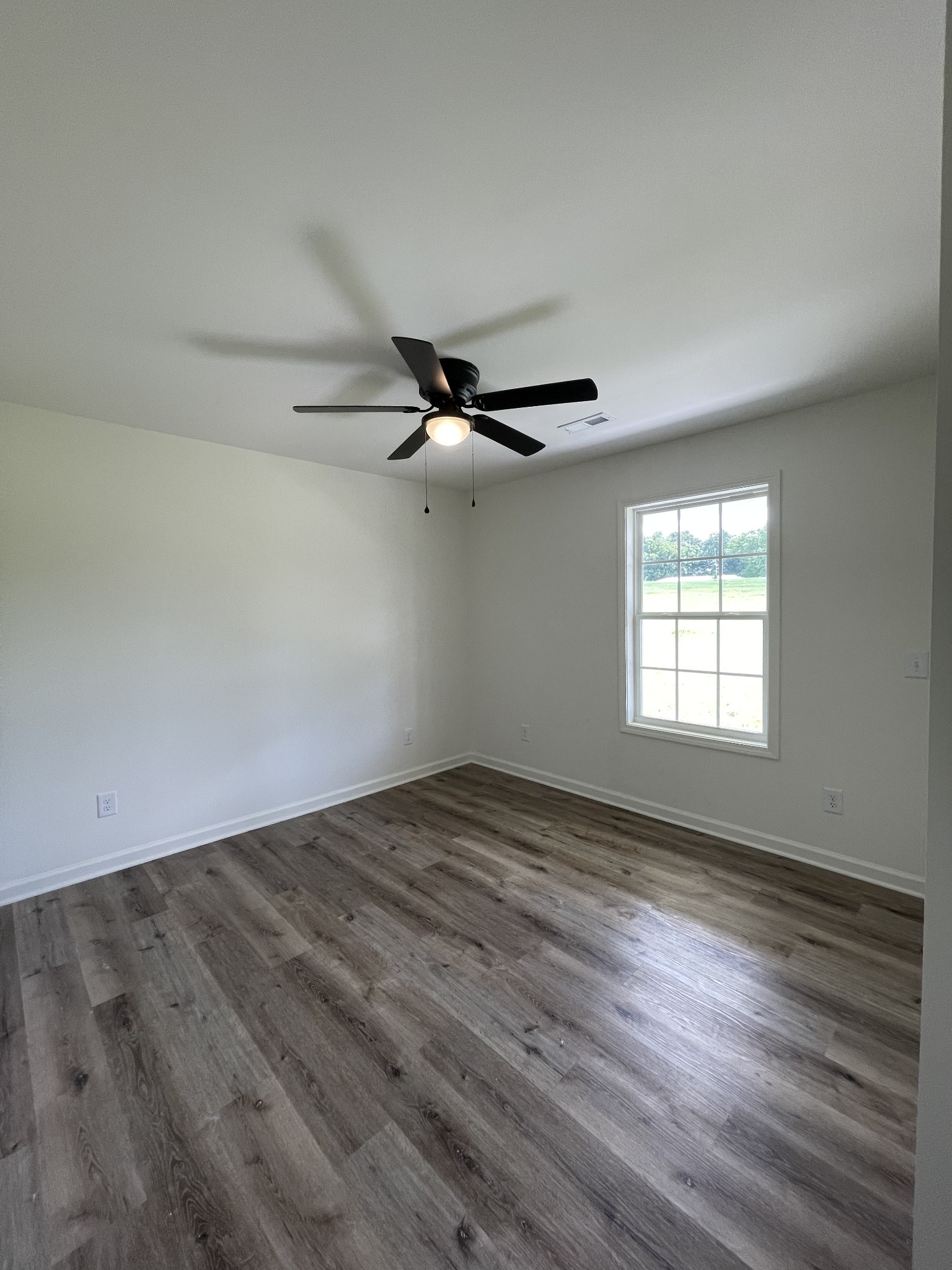2907 Union Camp Road Lafayette, TN 37083 - Photo 17 of 24 an empty room with wooden floor fan and windows
