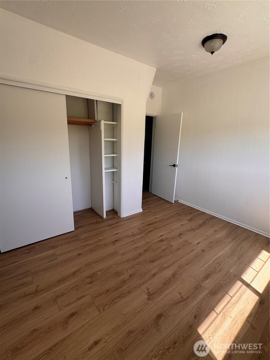 20016 Orville Road East Orting, WA 98360 - Photo 7 of 18 a view of an empty room with wooden floor and closet