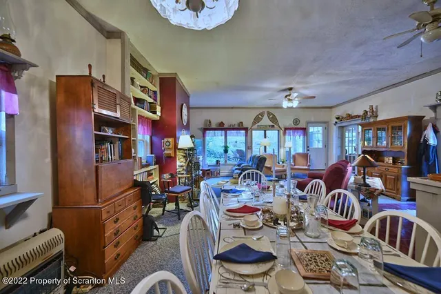 a living room with furniture a ceiling fan and a large window
