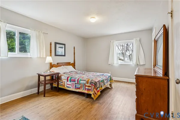 a bedroom with a bed wall painting and a window