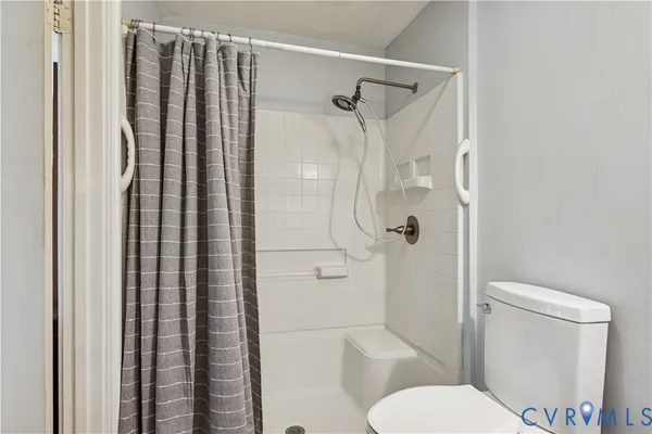 a bathroom with a shower curtain and a toilet