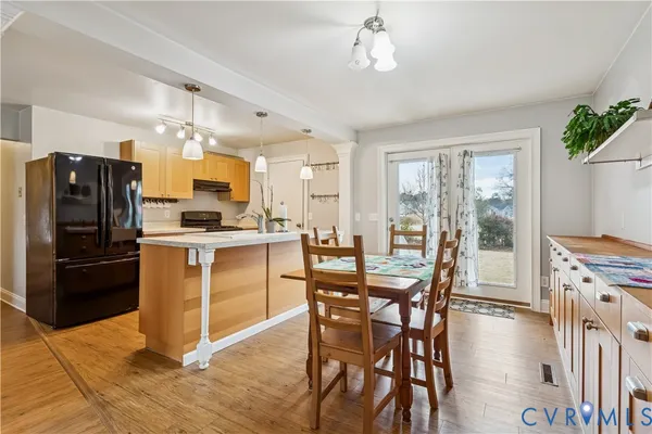 a kitchen with stainless steel appliances a dining table chairs stove refrigerator and microwave