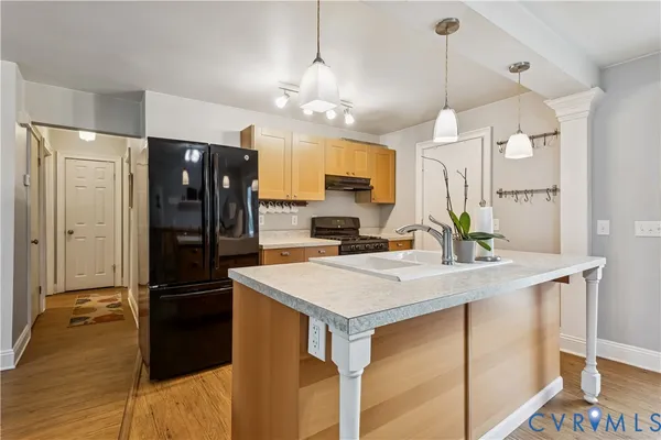 a kitchen with a refrigerator a sink and a stove top oven