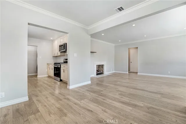 a kitchen with granite countertop white cabinets and stainless steel appliances