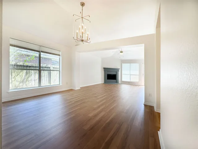 a view of empty room with wooden floor and fireplace