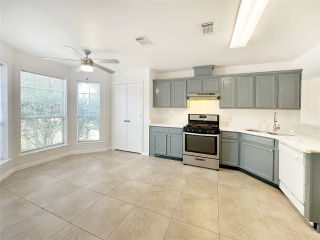 a large kitchen with cabinets and stainless steel appliances