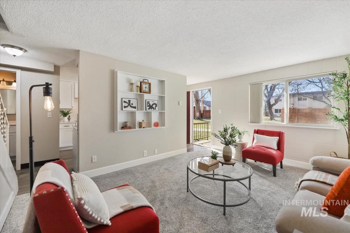 Living area featuring a textured ceiling and carpet flooring