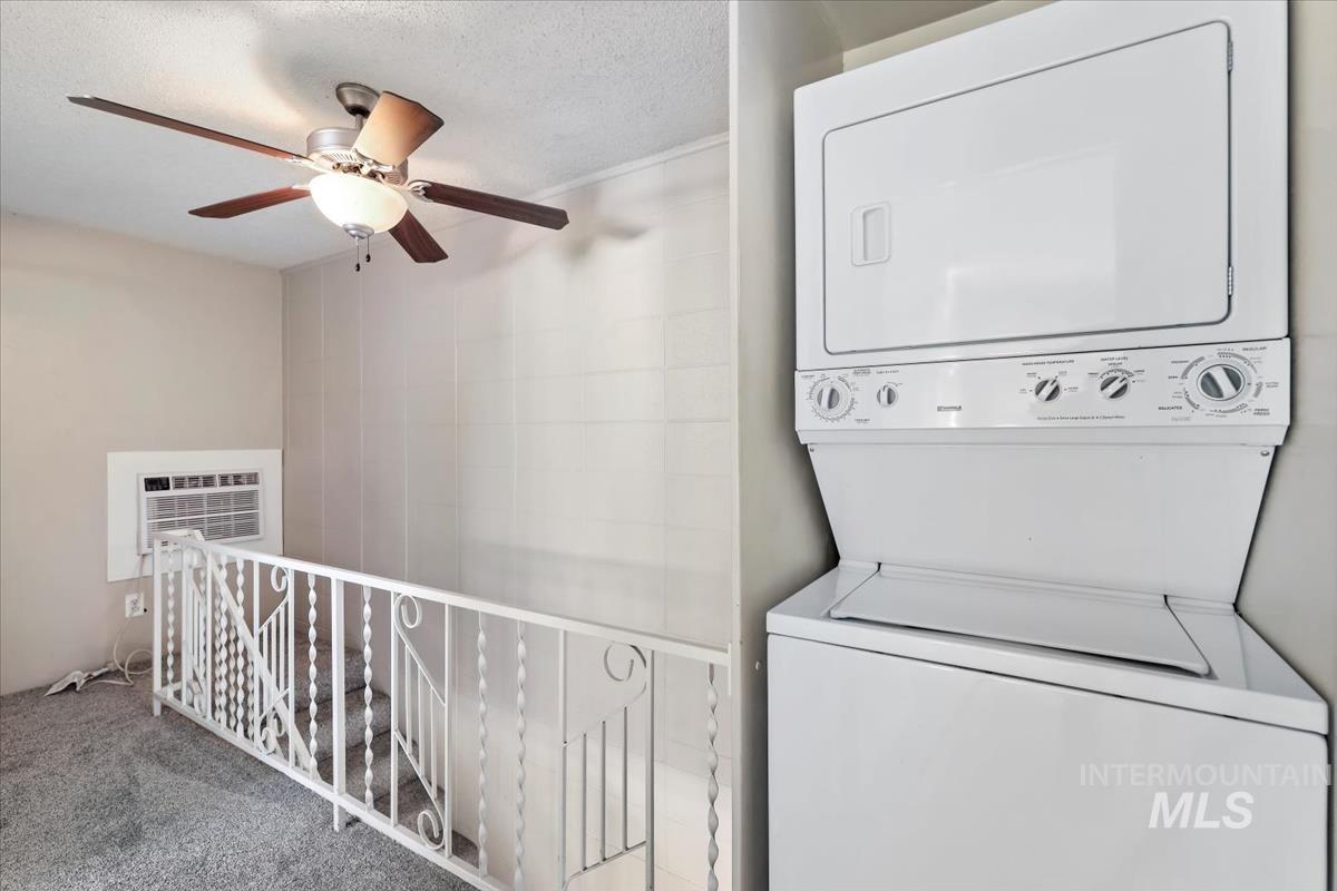 952 South Curtis Road Boise, ID 83705 - Photo 30 of 37 Laundry area with stacked washing machine and dryer, carpet floors, a textured ceiling, ceiling fan, and a wall mounted AC