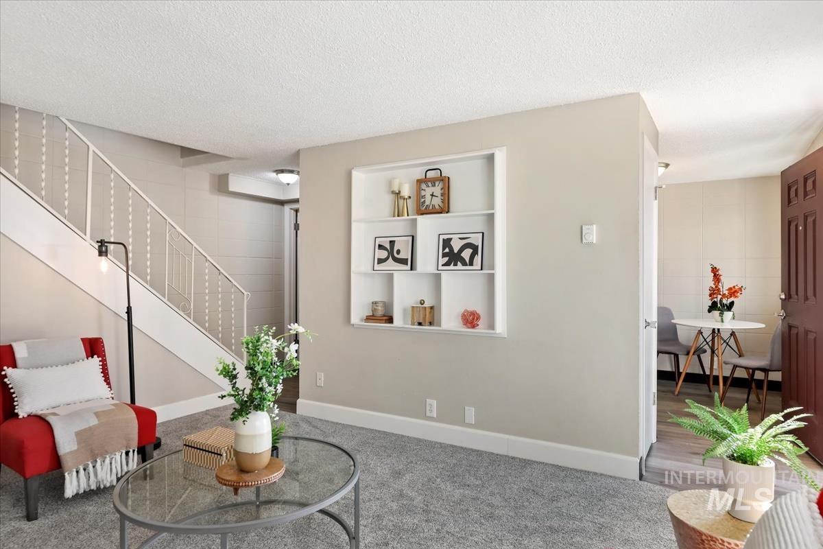 952 South Curtis Road Boise, ID 83705 - Photo 8 of 37 Living area with a textured ceiling, carpet, stairway, and built in shelves