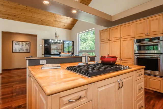 a kitchen with stainless steel appliances granite countertop a stove a sink and a microwave