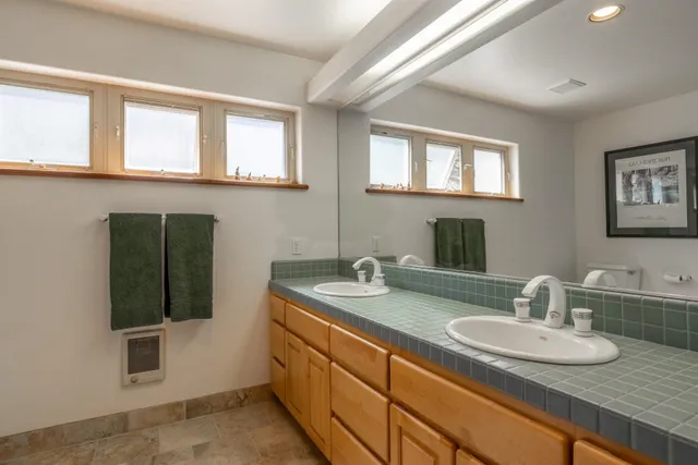 a bathroom with a granite countertop sink a mirror and a shower