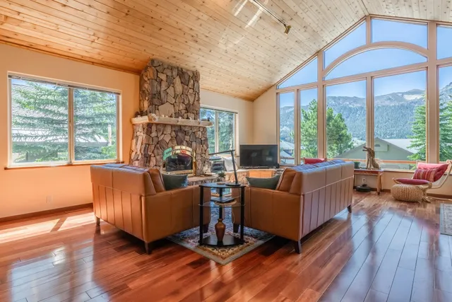 a living room with furniture a large window with wooden floor and walls