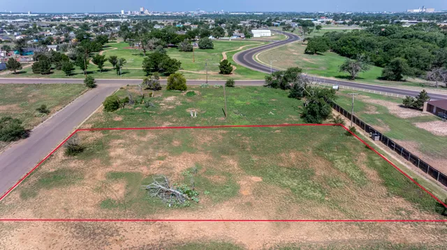 an aerial view of residential houses with outdoor space and trees