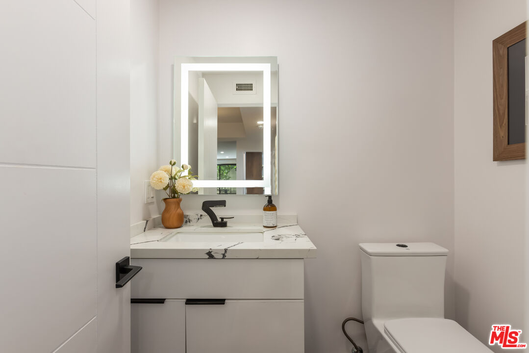 1210 North Kings Road, Unit 101 West Hollywood, CA 90069 - Photo 15 of 32 a bathroom with a sink toilet and mirror
