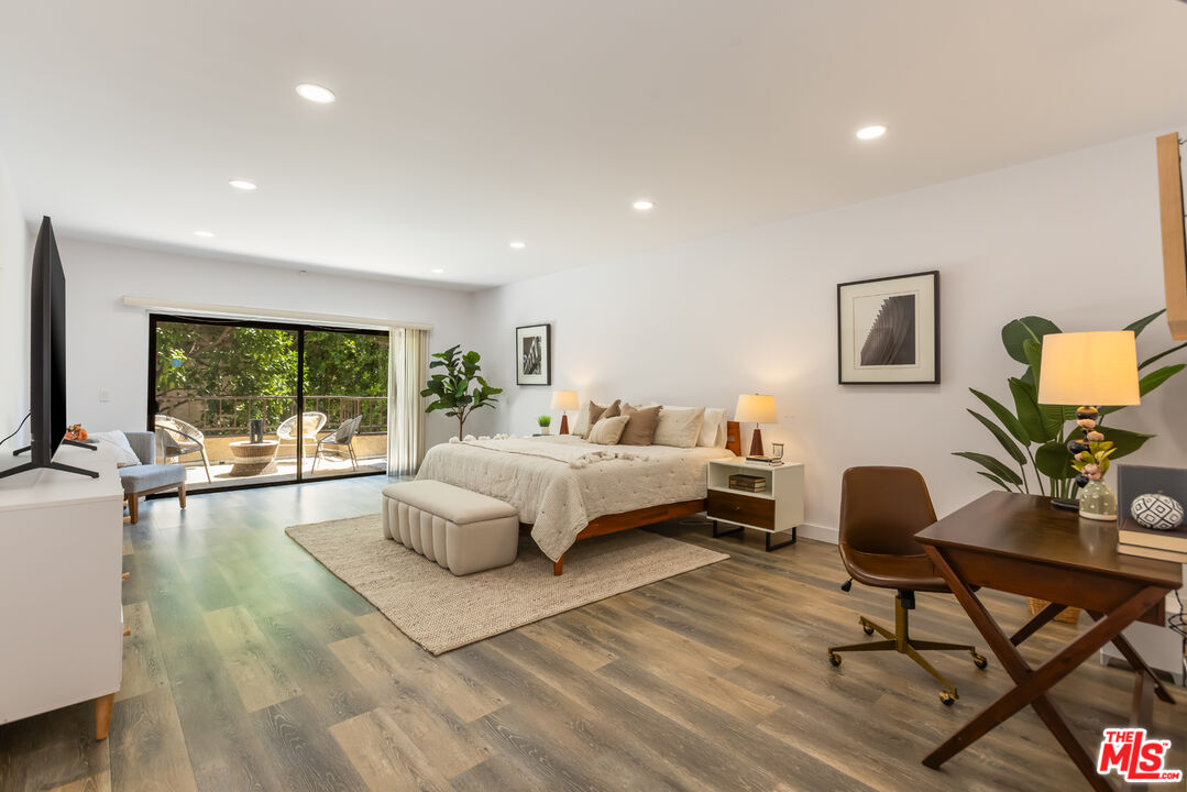 1210 North Kings Road, Unit 101 West Hollywood, CA 90069 - Photo 21 of 32 a bedroom with a bed and large windows