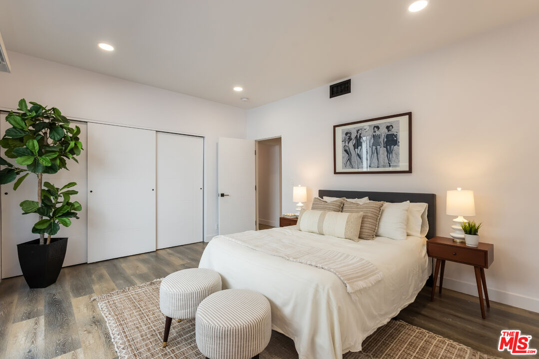 1210 North Kings Road, Unit 101 West Hollywood, CA 90069 - Photo 25 of 32 a bedroom with a bed and a potted plant