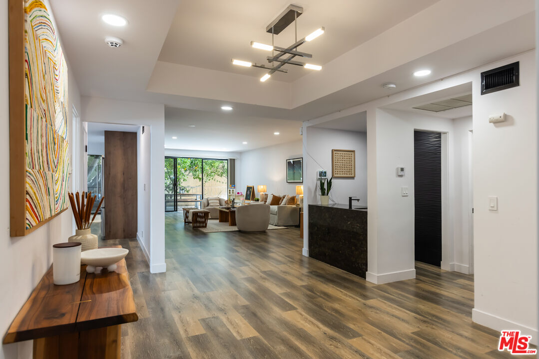 1210 North Kings Road, Unit 101 West Hollywood, CA 90069 - Photo 4 of 32 a living room with furniture and a chandelier