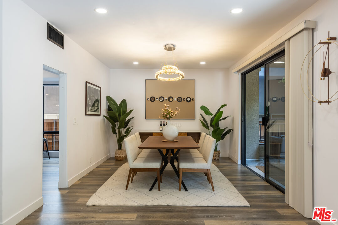 1210 North Kings Road, Unit 101 West Hollywood, CA 90069 - Photo 8 of 32 a view of a dining room with furniture and wooden floor