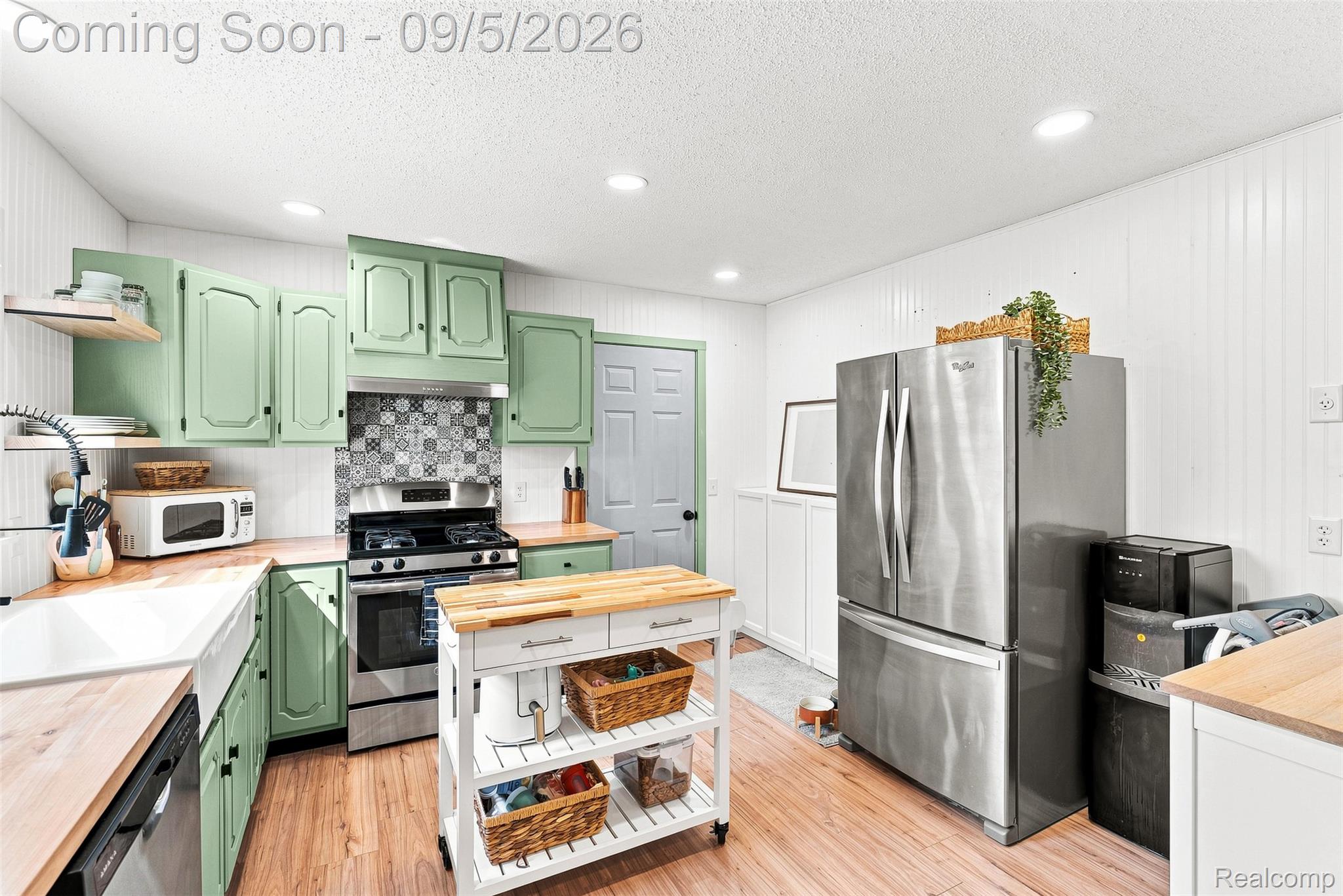 2071 East Dodge Road Clio, MI 48420 - Photo 13 of 38 Wood-finish flooring, recessed lighting, wood-finish countertops, stainless steel appliances, and a mosaic tile backsplash