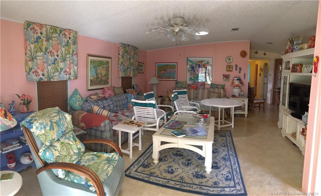 16222 Southwest Five Wood Way Indiantown, FL 34956 - Photo 4 of 13 a living room with furniture and a flat screen tv