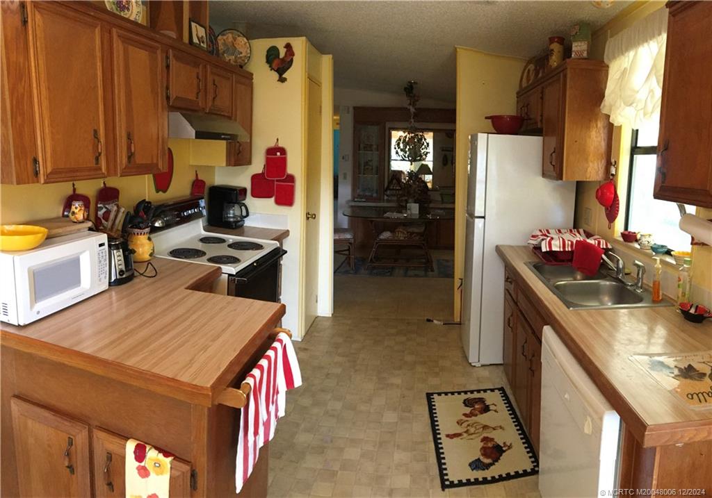 16222 Southwest Five Wood Way Indiantown, FL 34956 - Photo 5 of 13 a kitchen with a sink stove and refrigerator