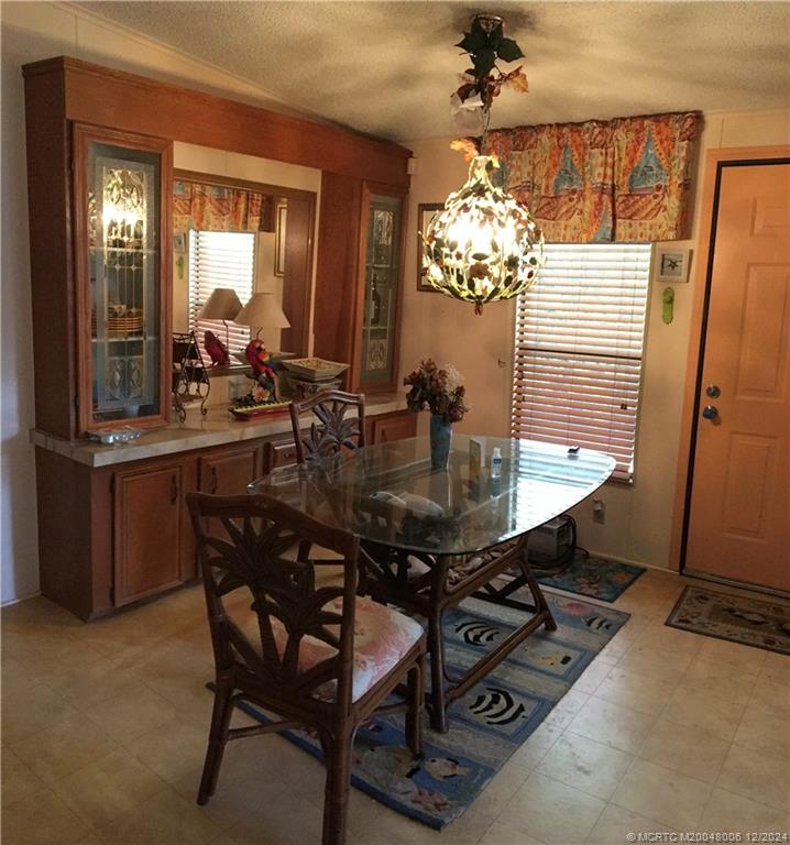 16222 Southwest Five Wood Way Indiantown, FL 34956 - Photo 7 of 13 a view of a dining room with furniture and chandelier