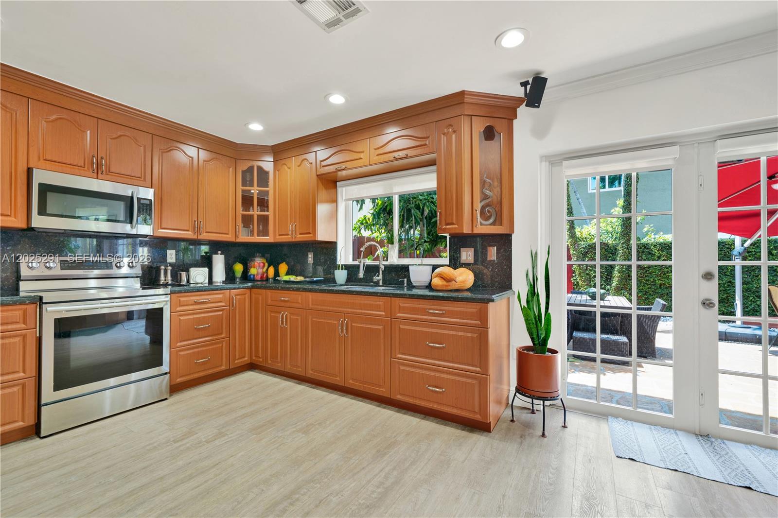 10006 Southwest 162nd Path Miami, FL 33196 - Photo 15 of 40 a kitchen with stainless steel appliances granite countertop a stove a sink and a refrigerator