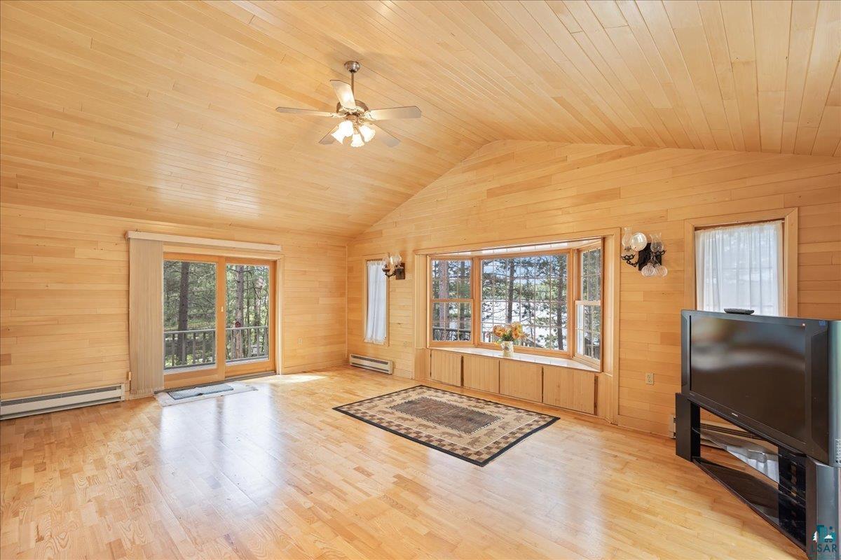 1804 North Bay Road Ely, MN 55731 - Photo 8 of 37 Living room featuring wood walls, a baseboard radiator, light hardwood / wood-style flooring, and wooden ceiling