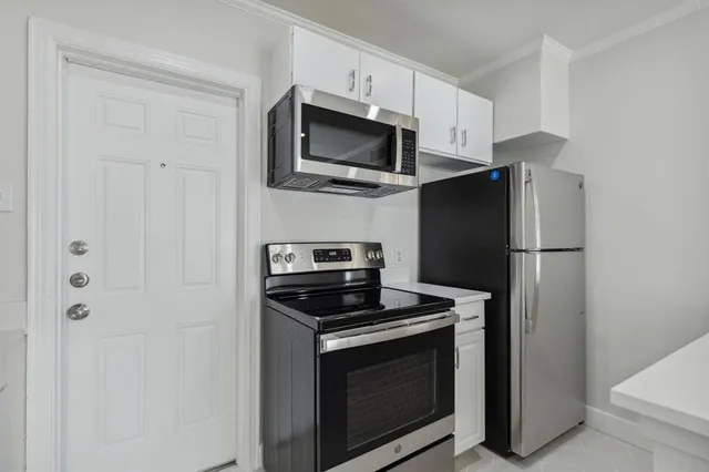 a kitchen with stainless steel appliances white cabinets stove and microwave
