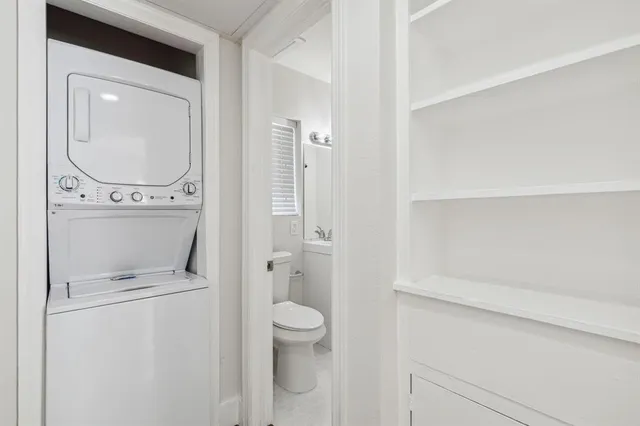 a bathroom with a granite countertop toilet and a sink