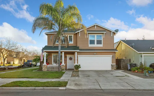 a front view of a house with a yard and garage