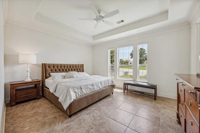 a spacious bedroom with a bed and a chandelier