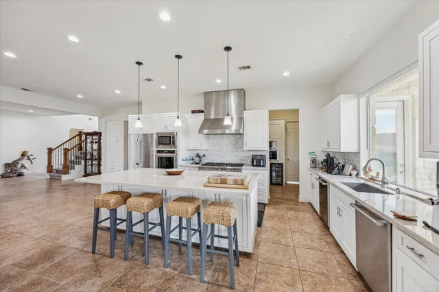 a large kitchen with kitchen island a large island a sink a stove and a center island