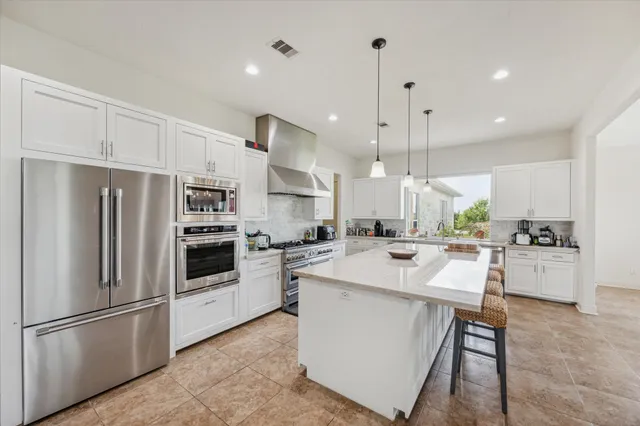a kitchen with white cabinets and white appliances