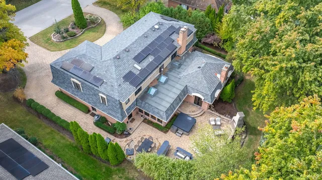 an aerial view of residential houses with outdoor space and parking