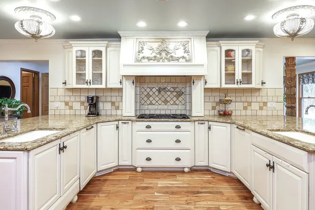 a kitchen with stainless steel appliances granite countertop a sink and cabinets with wooden floor
