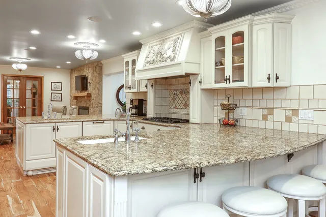 a kitchen with stainless steel appliances granite countertop a sink and a white cabinets