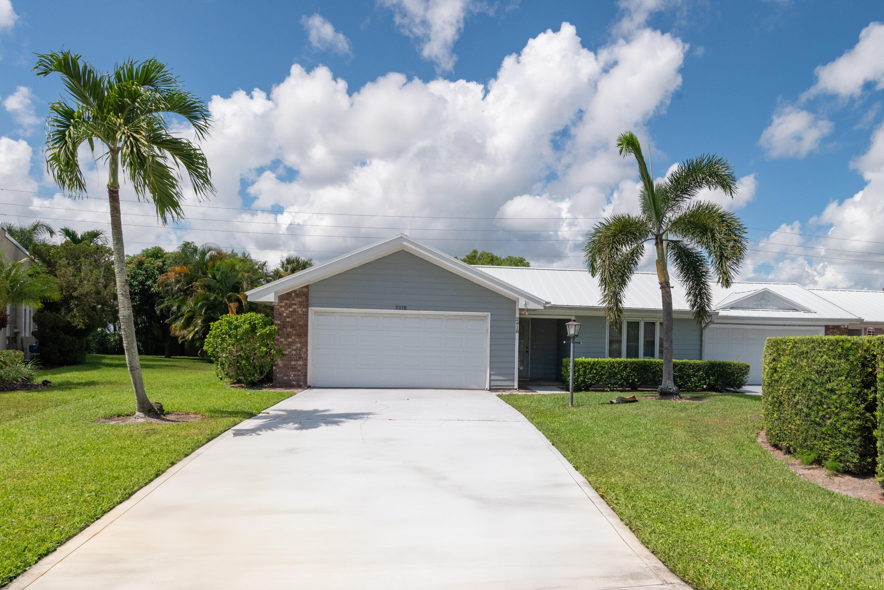 2918 Southeast Fairway West, Unit 13 Stuart, FL 34997 - Photo 2 of 35 a front view of house with yard and green space