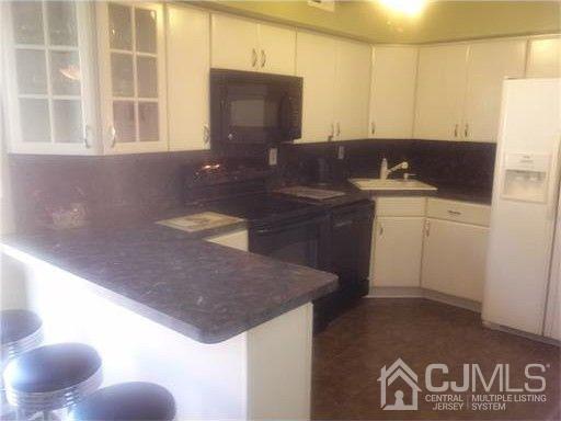 a kitchen with granite countertop a sink a stove and a microwave