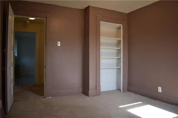 an empty room with closet and a bathroom
