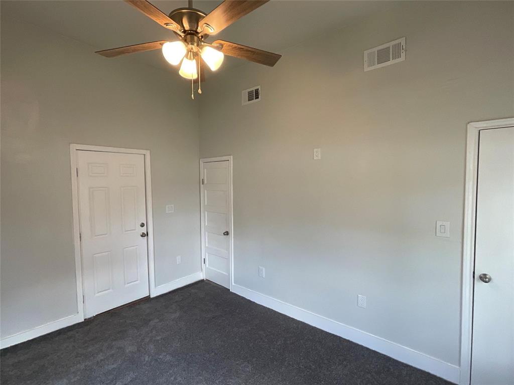 207 College Street Chico, TX 76431 - Photo 20 of 20 Unfurnished room with dark colored carpet, a high ceiling, and a ceiling fan