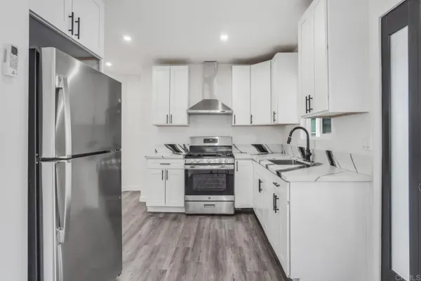 a kitchen with a refrigerator sink and cabinets